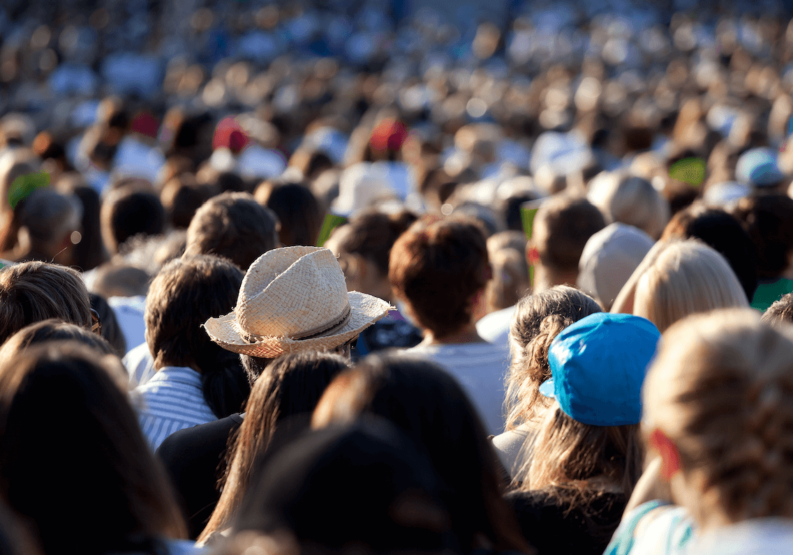 A female student is smiling as she looks down to her laptop, as she has her hands hovering slightly over its keyboard.